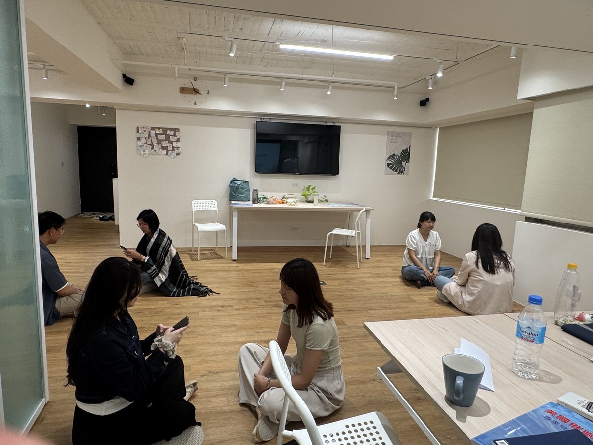 學員分成幾組，坐在教室地板上交流練習