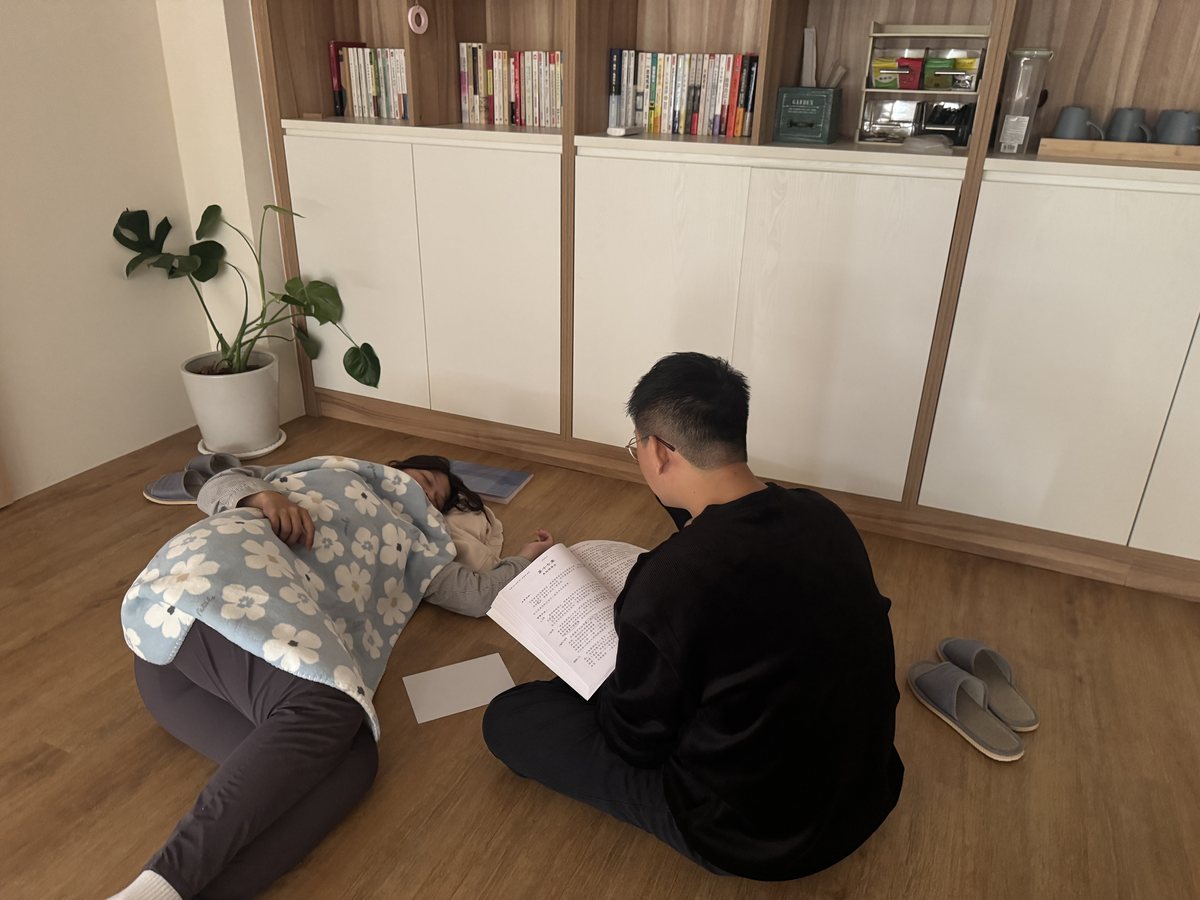 一位學員躺著練習催眠引導，另一位在旁記錄